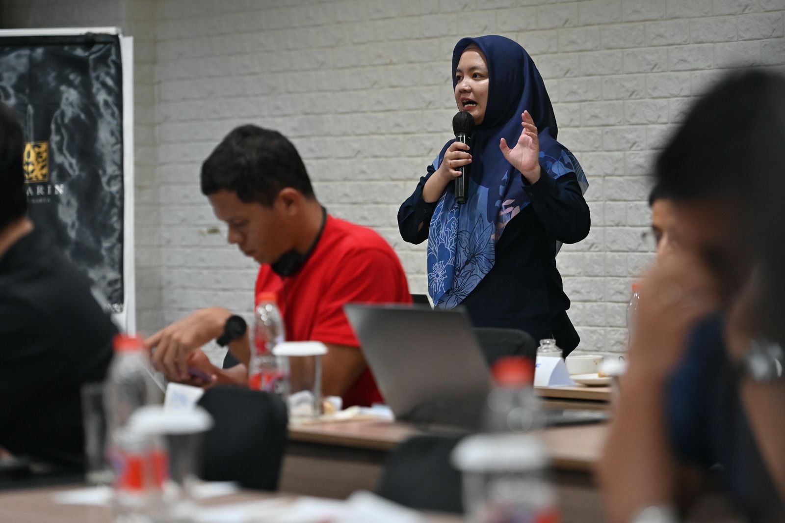 A delegate speaking into a microphone during a TUED strategy session