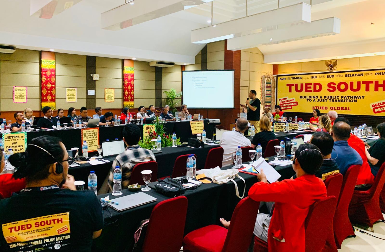 TUED South Asia-Pacific plenary in Indonesia — delegates seated around tables with union banners and a large TUED SOUTH banner