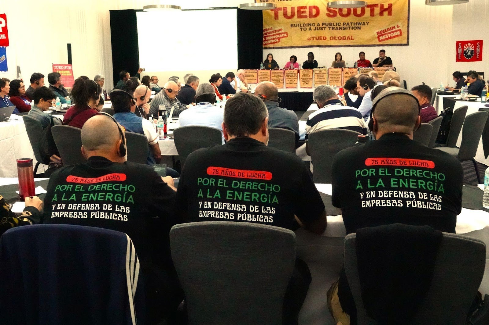 Mexican SME union delegates wearing shirts reading Por el derecho a la energía at a TUED South session